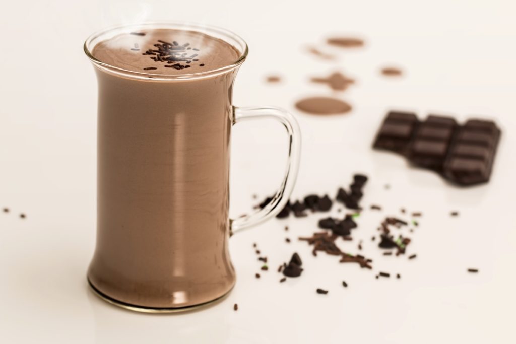 Hot chocolate with a chocolate bar in the background.