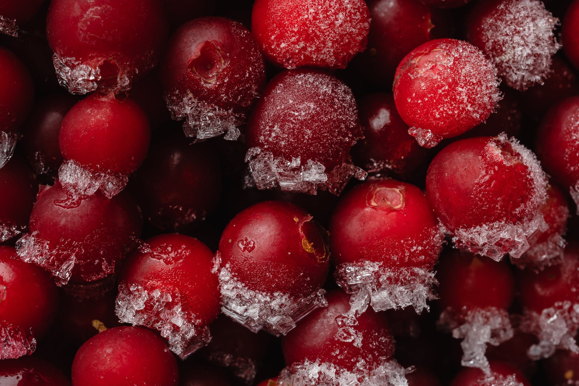 frozen red round fruits- possibly cranberries which as available in the frozen aisle of many supermarkets globally. Food date labels for frozen fruit relate to food quality rather than safety.